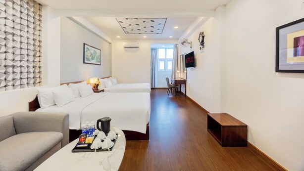 Une chambre d’hôtel avec un lit, un canapé, un bureau et une télévision.