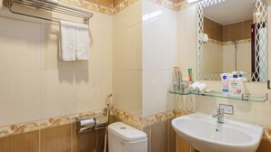 Une salle de bain équipée de toilettes, d’un lavabo et d’un porte-serviettes.