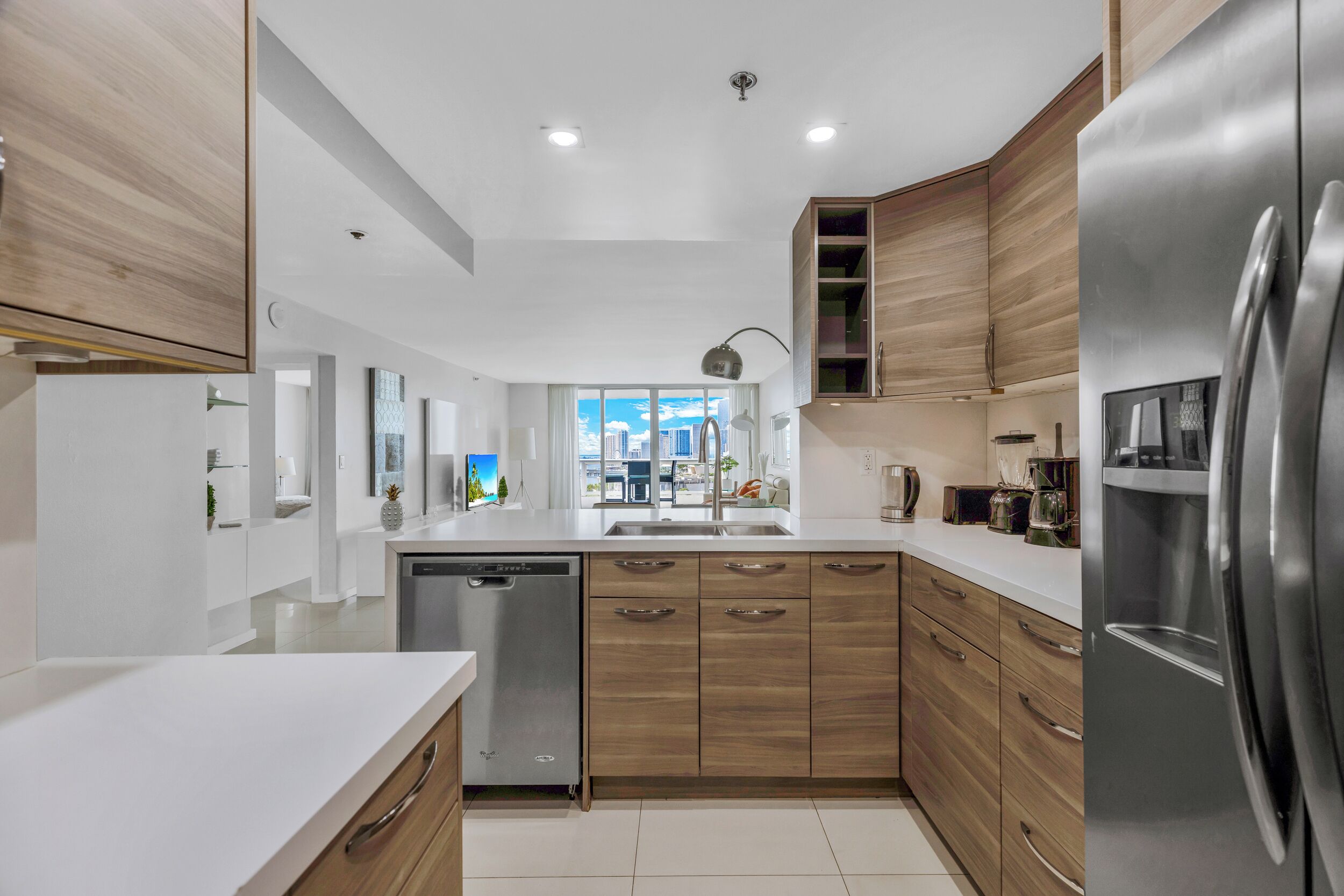 A modern kitchen with wooden cabinets, stainless steel appliances, and a large island.