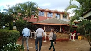 A building with a red roof and a covered patio area. - Jambo Village Hotel (Murang'a)