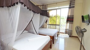 Habitación con dos camas, ventilador de techo y televisor.