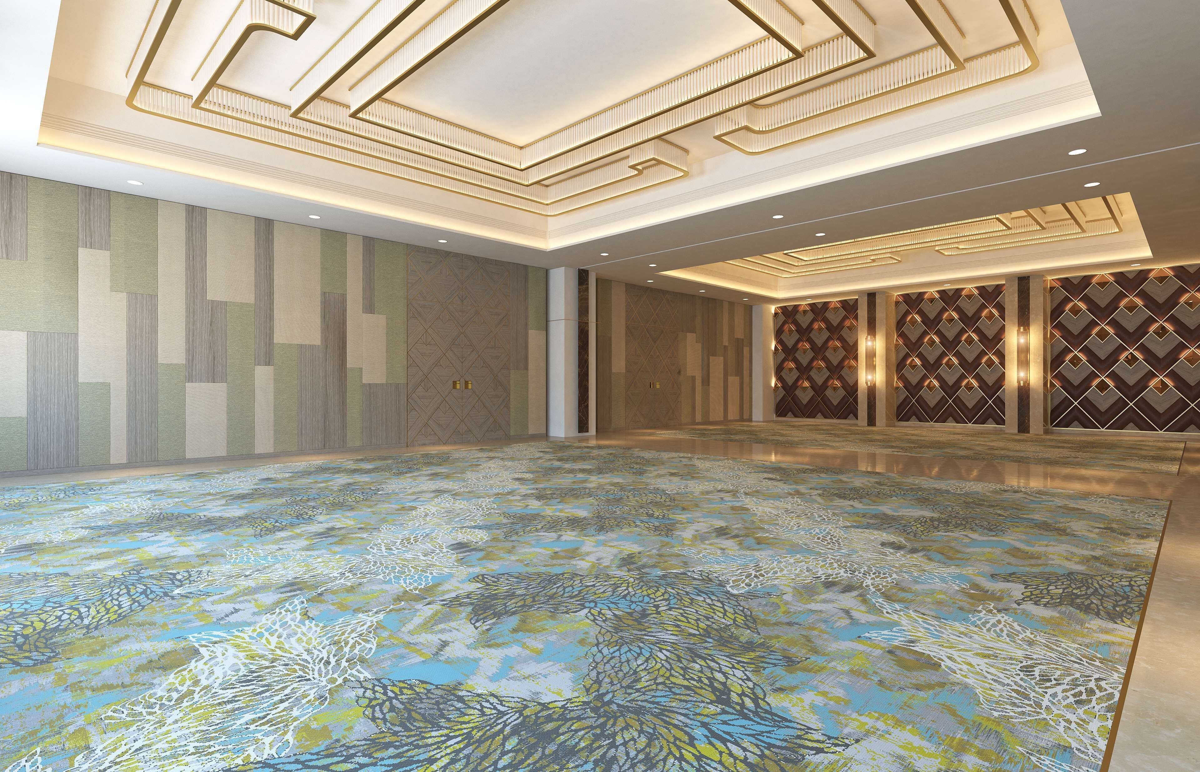 A spacious room with patterned walls, a decorative ceiling, and a colorful floor.