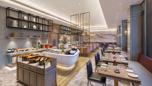 A modern hotel lobby with a central island, seating area, and a variety of amenities including a buffet and decorative elements.