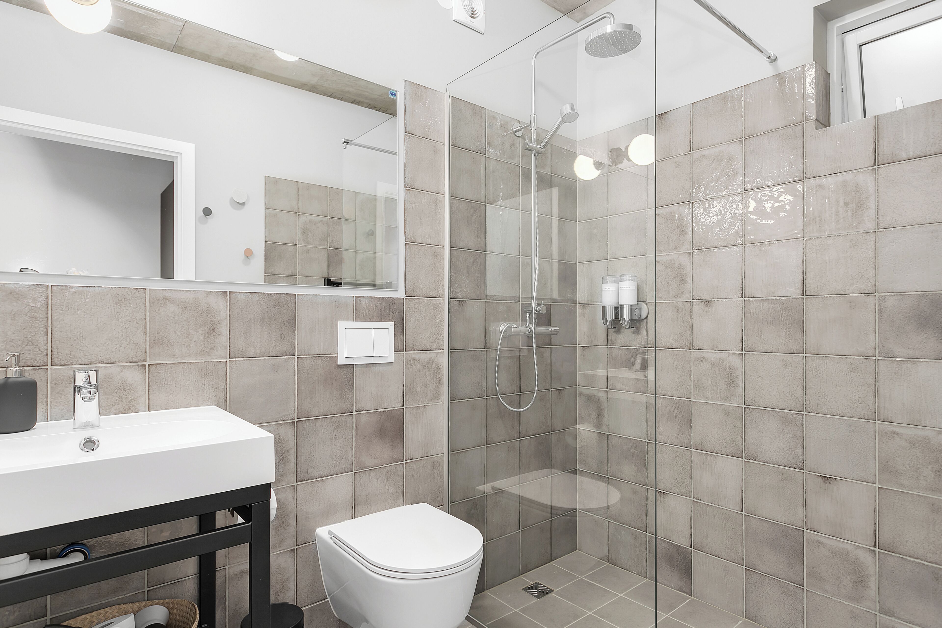 Un baño moderno con ducha, inodoro y lavabo.