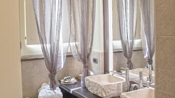 A bathroom with two sinks, a large mirror, and a shower curtain.