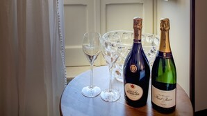 A table with two bottles of wine and several glasses on a balcony overlooking a cityscape. - Perlage Suite Luxury B&B (Alberobello)