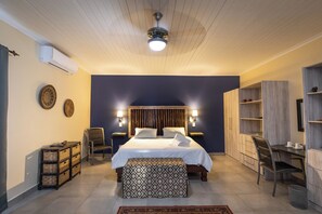 A modern bedroom with a bed, bedside tables, a desk, and a chair. - Asuite-Dream (Hoedspruit)