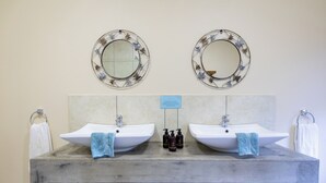 Une salle de bain avec deux lavabos, deux miroirs et un meuble-lavabo en bois.