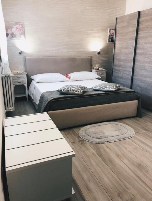 Ein modernes Schlafzimmer mit einem Bett, Nachttischen und einem kleinen Teppich.