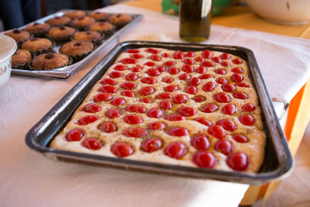 A tray of baked goods with cherries on top, placed on a table.