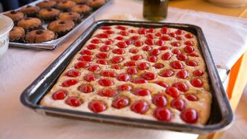 A tray of baked goods with cherries on top, placed on a table.