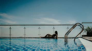 Een buitenzwembad, een infinity pool, parasols voor strand/zwembad