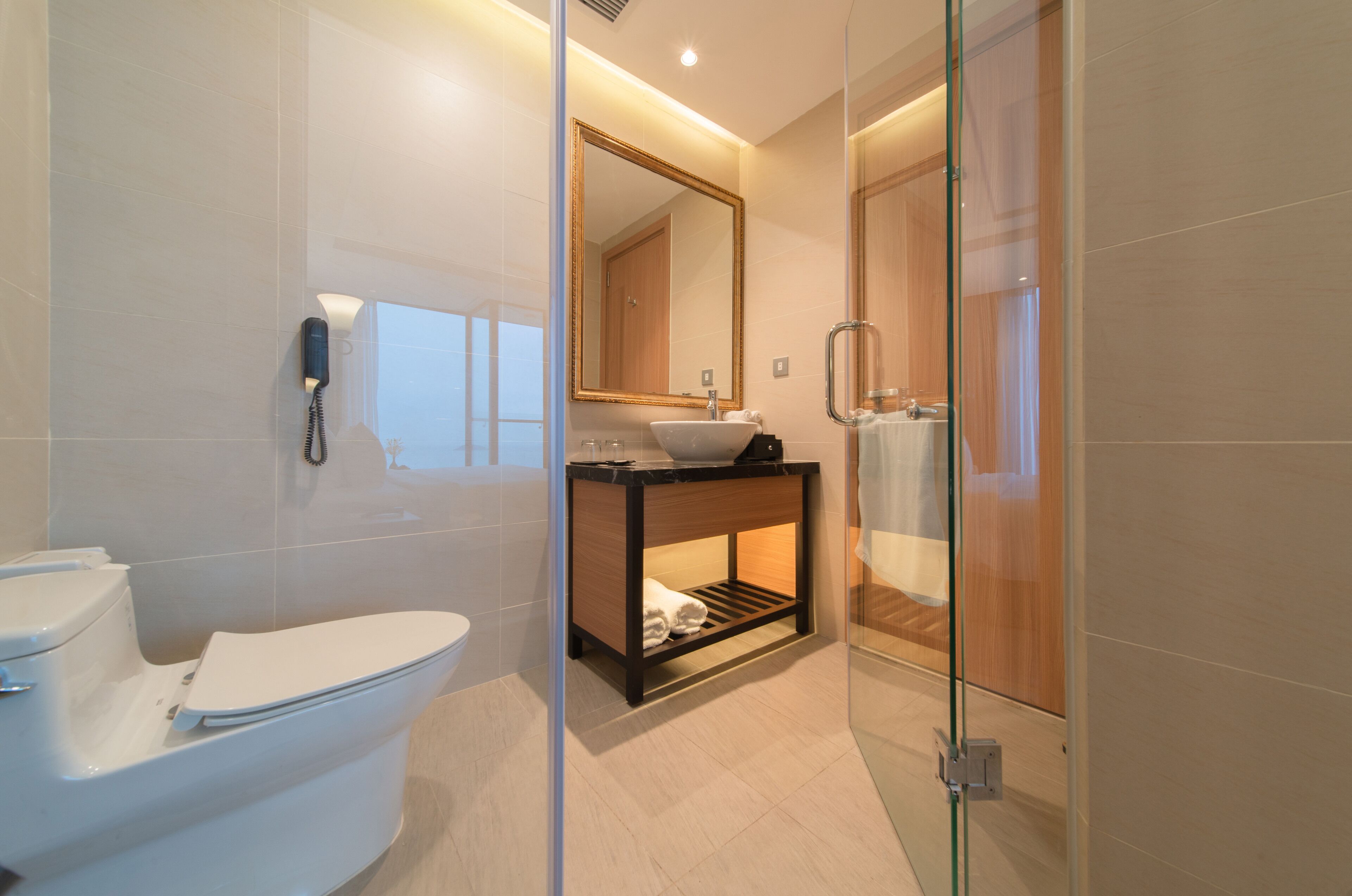 A modern bathroom with a toilet, sink, and glass-enclosed shower.