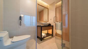 A modern bathroom with a toilet, sink, and glass-enclosed shower.