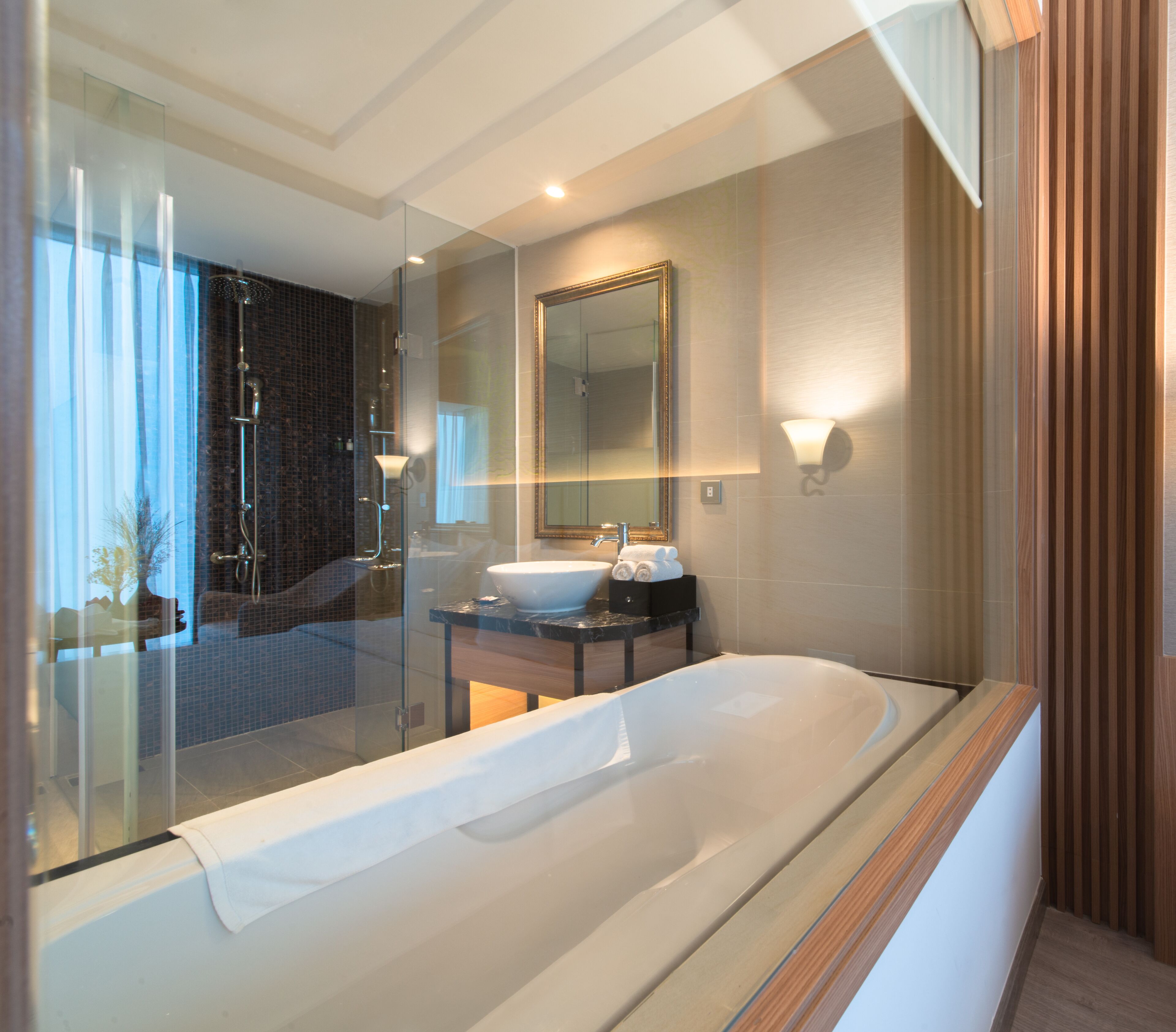 Ein modernes Badezimmer mit einer einteiligen Duschkabine, einer großzügigen Badewanne und einem Waschtisch mit Spiegel.