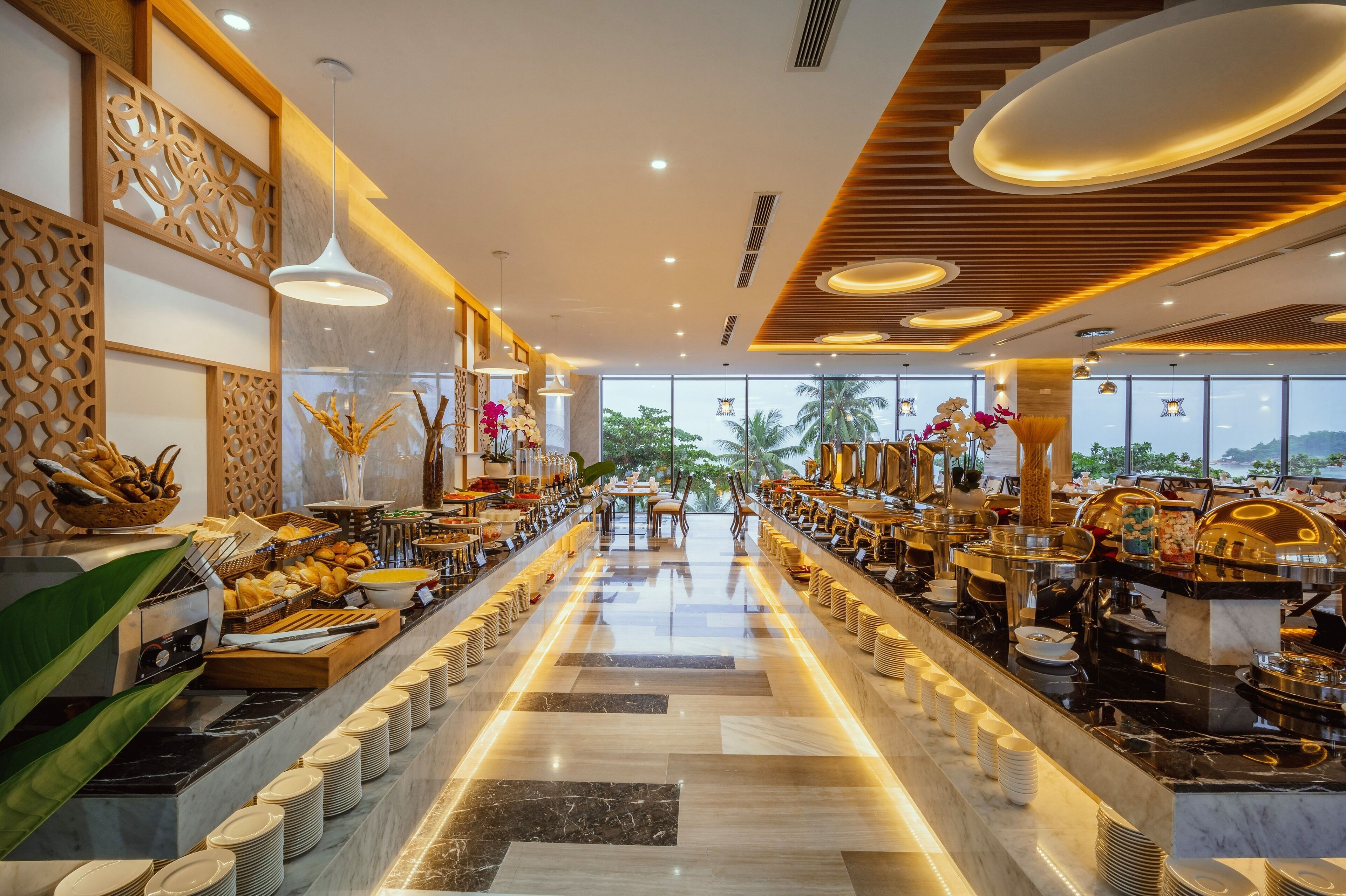 Un buffet proposant une variété de plats et un long comptoir où sont disposées les assiettes.