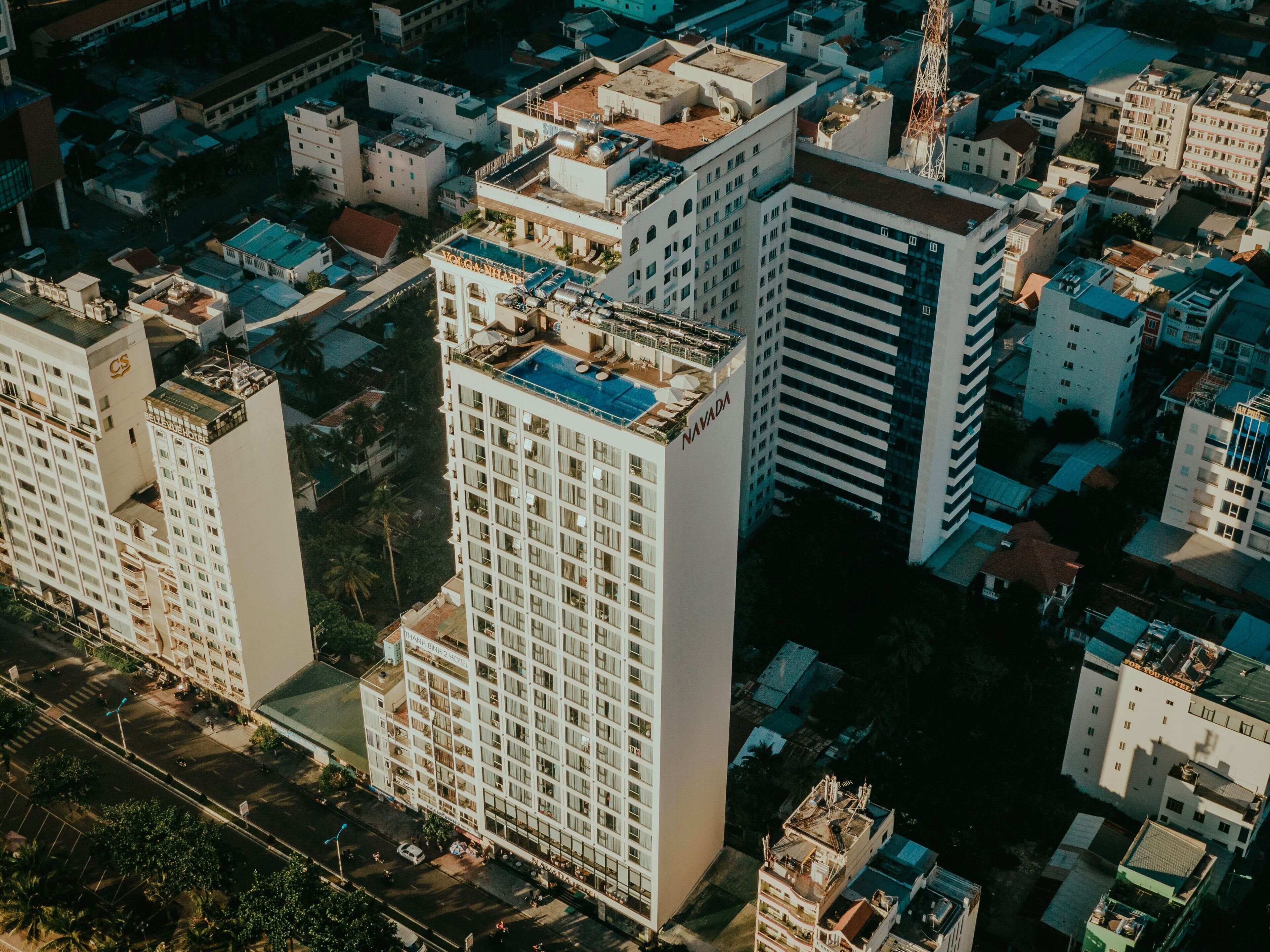 A high-rise hotel with multiple floors, a rooftop pool, and a prominent 'Navada' sign.