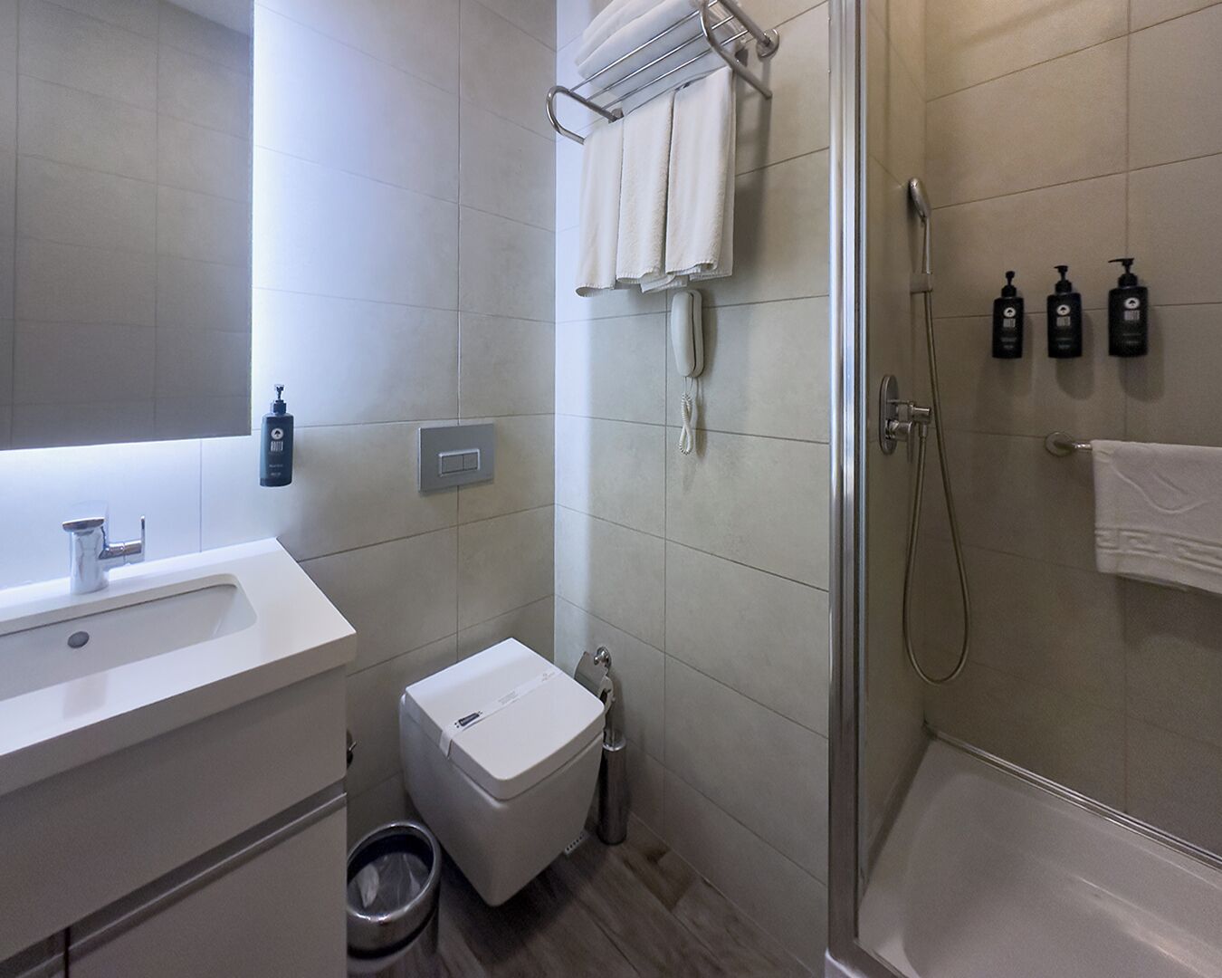 A modern bathroom with a sink, toilet, and shower.