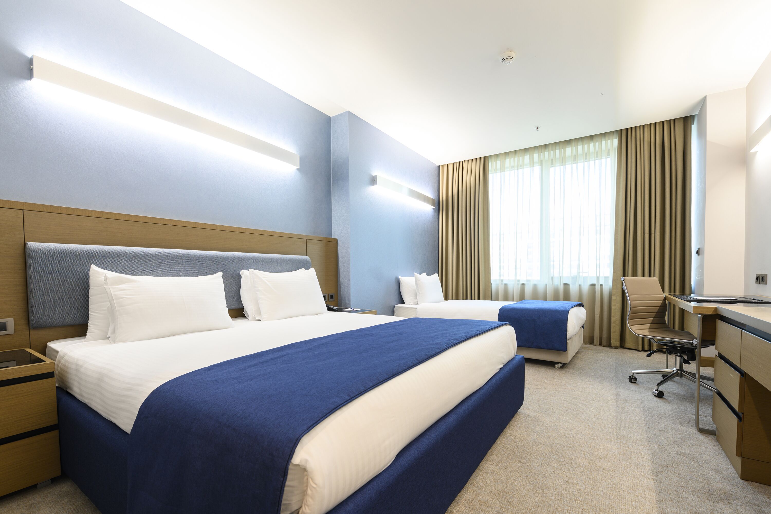 Ein Hotelzimmer mit einem großen Bett, einem Schreibtisch und einem Stuhl.