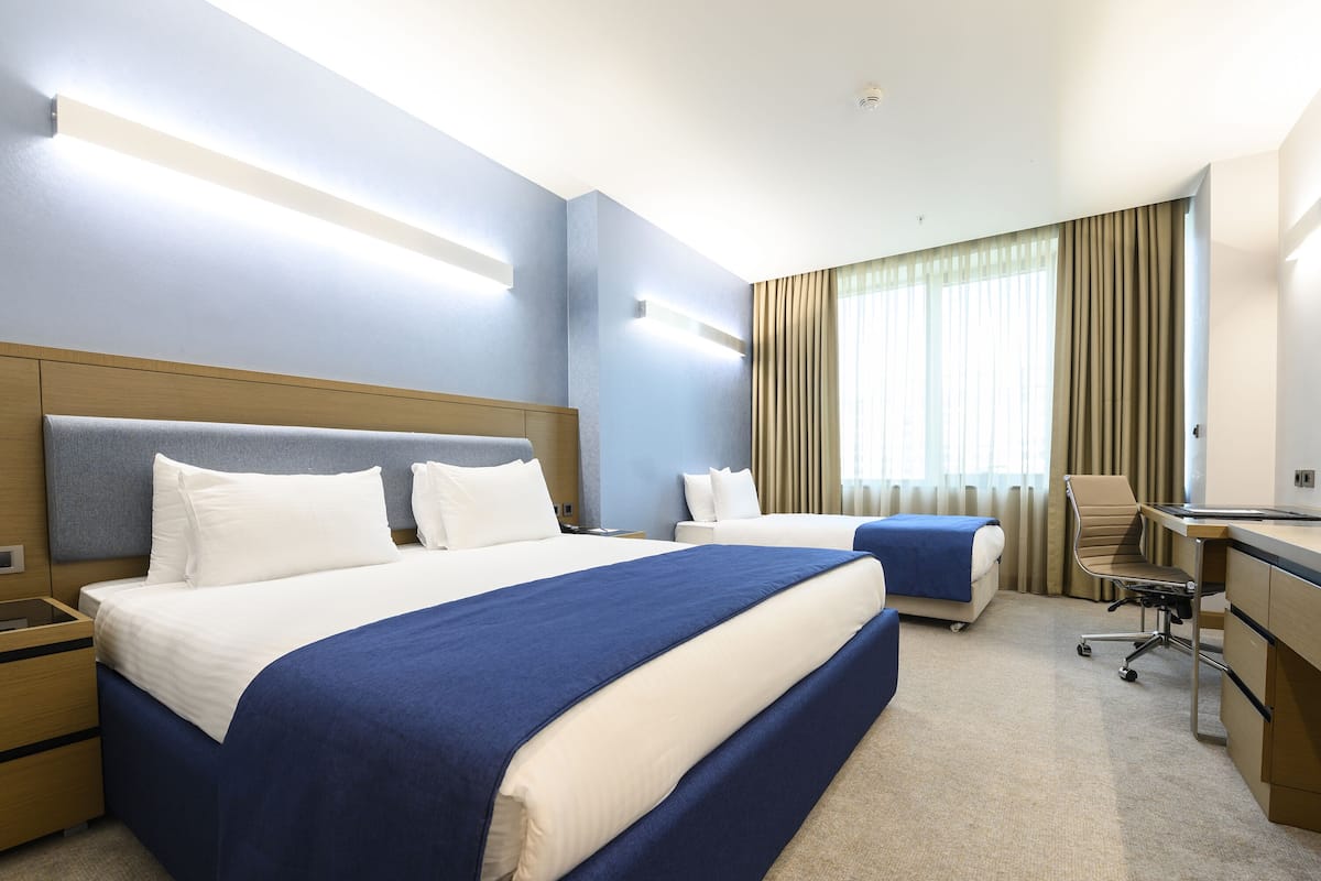 Ein Hotelzimmer mit einem großen Bett, einem Schreibtisch und einem Stuhl.