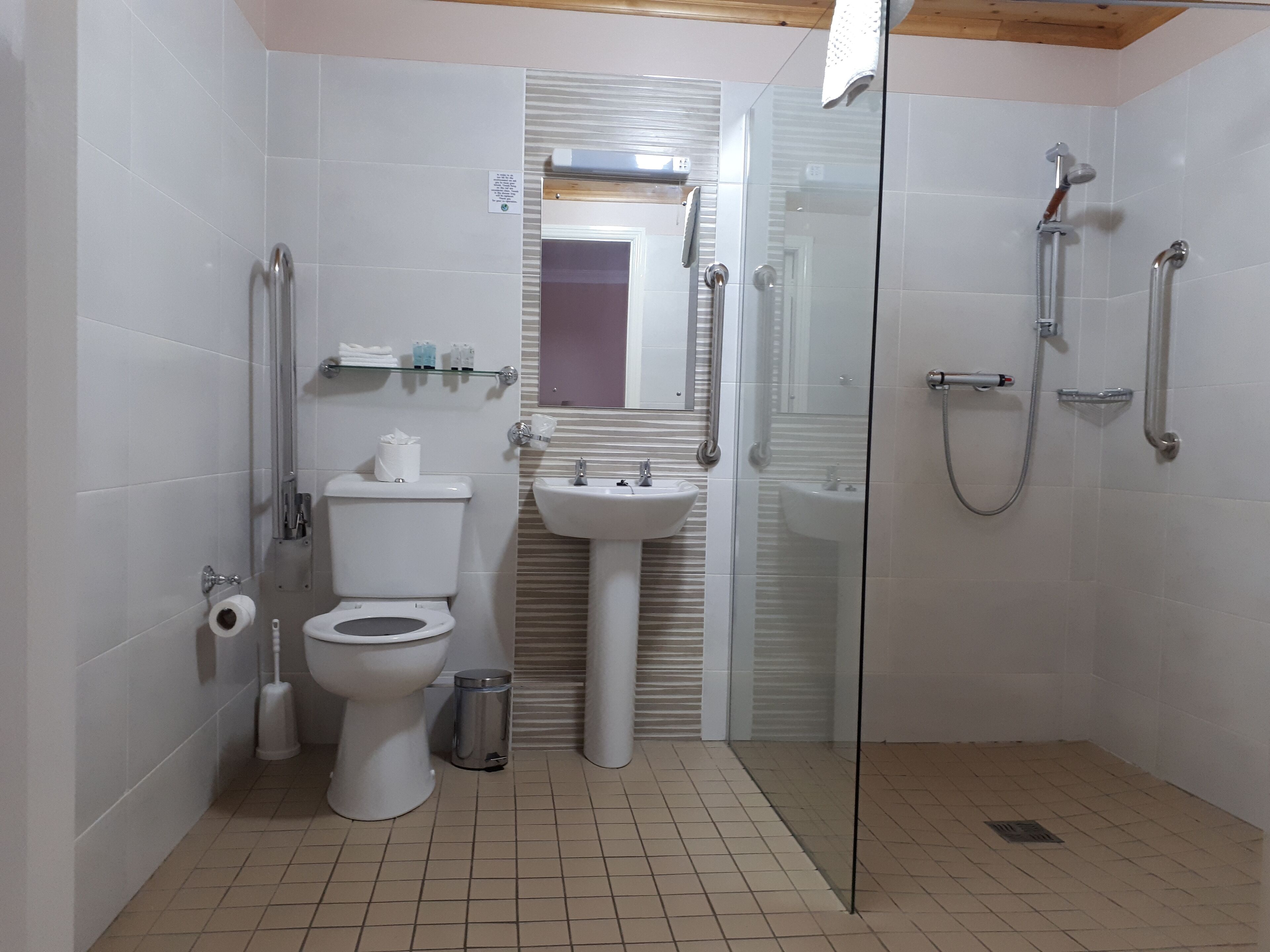 Un bany modern amb vàter, bidet, rentapel i plat de dutxa amb envàs de vidre.