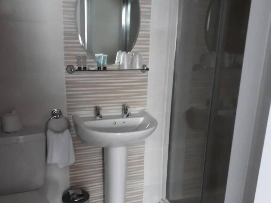 Une salle de bain avec des toilettes, un lavabo et une douche.