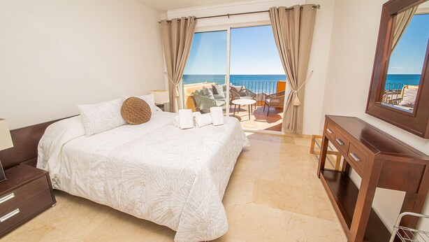 A hotel room with a bed, a desk, a chair, and a view of the sea. - Los Granados de la Duquesa 1522 (Manilva)