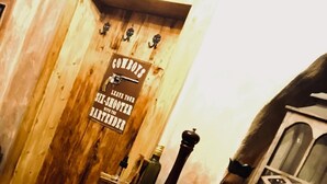 A rustic bar area with wooden walls, a sign reading "GONBOTS," and various bar items like bottles and baskets. - Atmosfera (Loket)