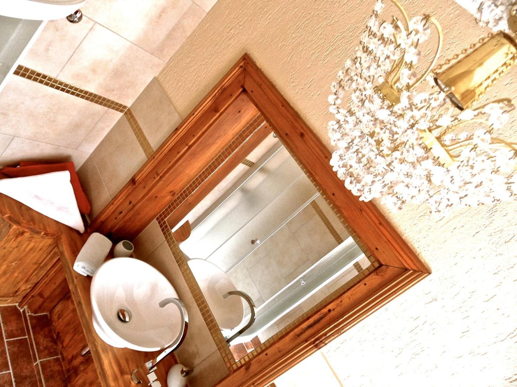 A bathroom with a wooden vanity, a sink, and a mirror.