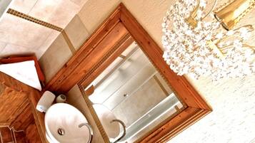 A bathroom with a wooden vanity, a sink, and a mirror.