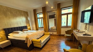 A hotel room with a large bed, a desk, a chair, and a television. - Atmosfera (Loket)