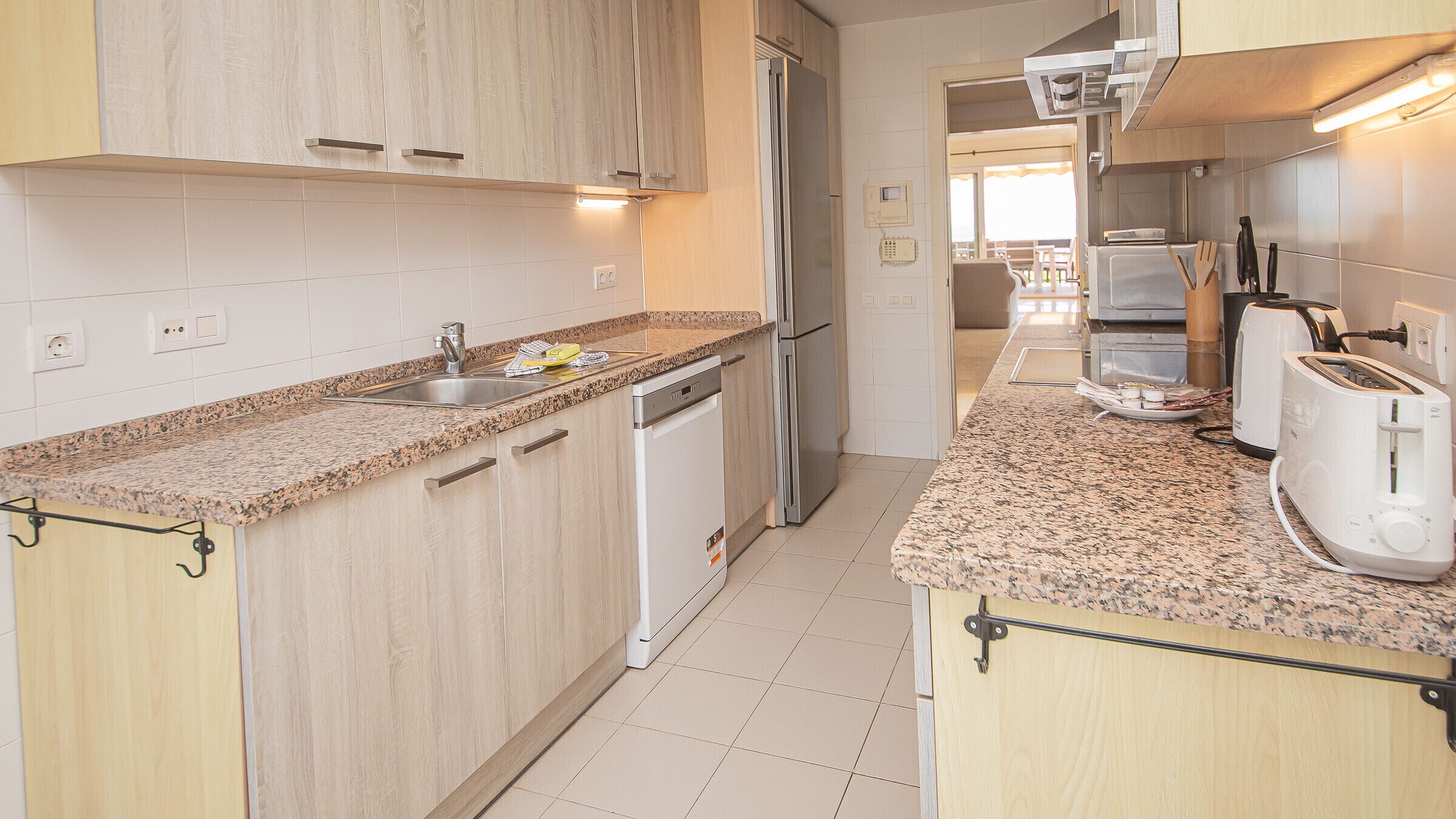 A modern kitchen with granite countertops, stainless steel appliances, and wooden cabinetry.