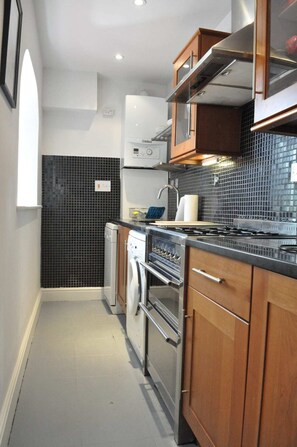 A compact kitchen with a built-in oven, a microwave, and a stove.