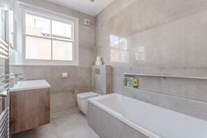 Ein modernes Badezimmer mit Toilette, Waschbecken und Badewanne.