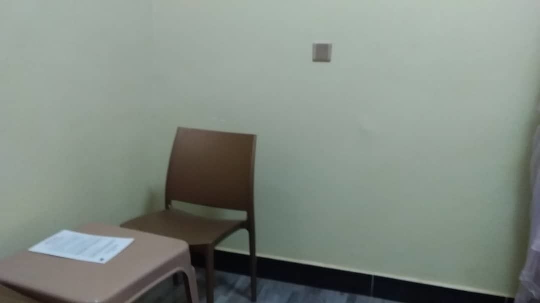 Une pièce avec une seule chaise marron et une petite table.