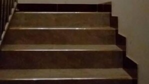 A staircase with dark steps and a white wall. - Faida Hill Motel (Kampala)