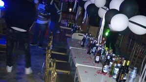 A row of tables with chairs, decorated with balloons and bottles, in a dimly lit indoor setting. - Faida Hill Motel (Kampala)