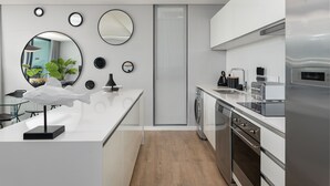 A modern kitchen with white cabinetry, a built-in dishwasher, and a stainless steel refrigerator. - Warwick 401 - Adults Only (Cape Town)