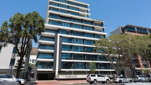 A multi-story building with a modern architectural design, featuring a prominent entrance with a sign. - Warwick 401 - Adults Only (Cape Town)