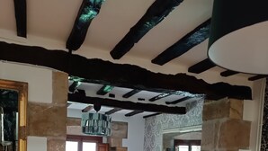 Un salon chaleureux avec un mur en pierre, un canapé, une table basse et une cheminée.
