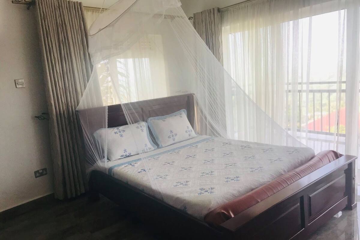 Un dormitorio con cama, cortinas y mosquitero.