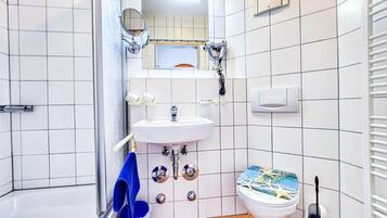 Ein Badezimmer mit Waschbecken, Spiegel, Toilette und einem blauen Handtuch an der Wand.