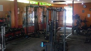 A gym with various exercise equipment, including weight machines and dumbbells. - Laguno Bed and Breakfast (Moalboal)