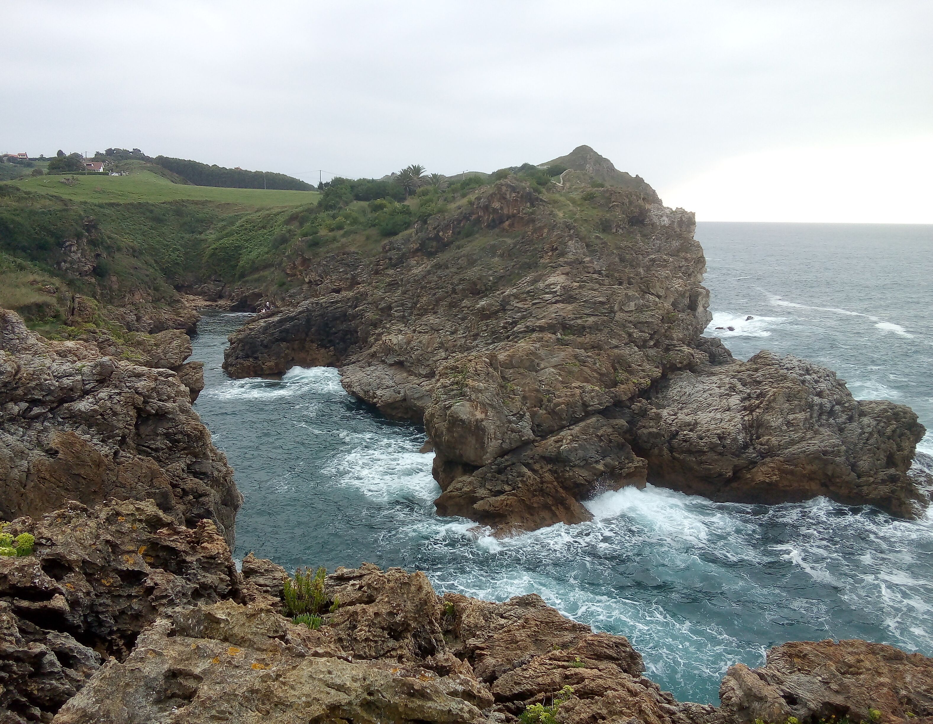 A coastal landscape with rocky cliffs and a narrow waterway.