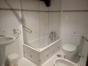 Une salle de bain avec une douche à parois de verre, un lavabo, des toilettes et un bidet.