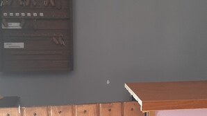 A room with a wooden panel wall, a globe, a no-smoking sign, a key rack, and two potted plants. - Galant Hotel (Boryspil)