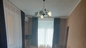 A hotel room with a large bed, a bedside table, a lamp, and a window with curtains. - Galant Hotel (Boryspil)