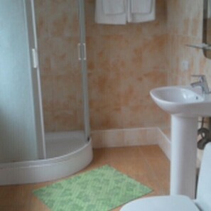 Ein Badezimmer mit Dusche, Waschbecken und Toilette.