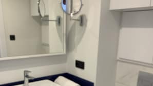 A modern bathroom with a white sink, a mirror, and a toilet. - Orbi city Davide (Batumi)