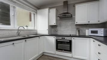 Klassiek appartement, 2 slaapkamers, niet-roken | Privékeuken | Een koelkast met diepvriezer, een microgolfoven, een oven, een kookplaat